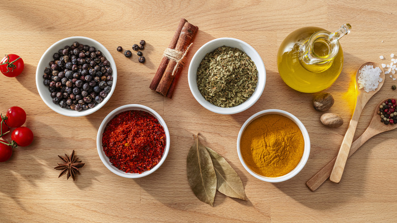 Variety of spices in white bowls and some oil