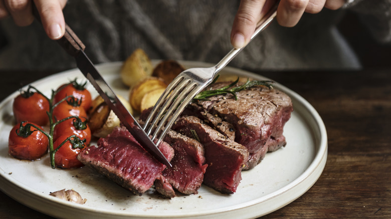 Person cutting into steak 