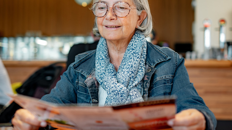 Woman reading a laminated restaurant menu