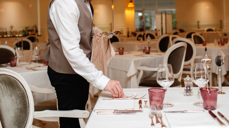 Waiter laying out silverware