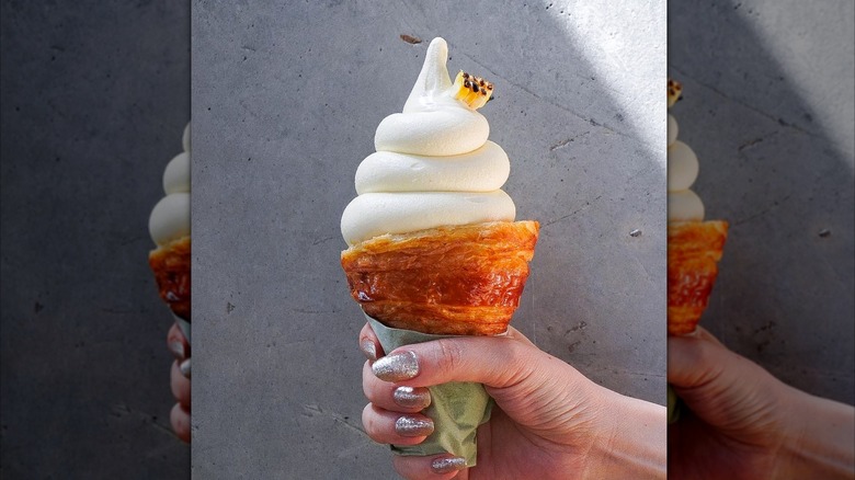 Hand holding soft serve in croissant cone