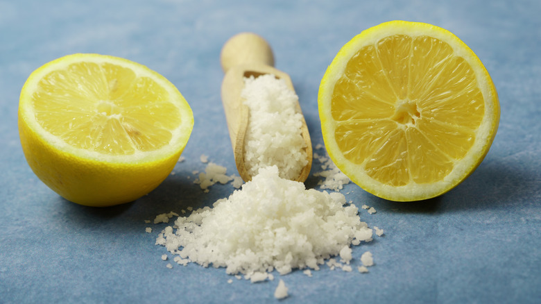 Salt on a blue surface with a lemon cut in half