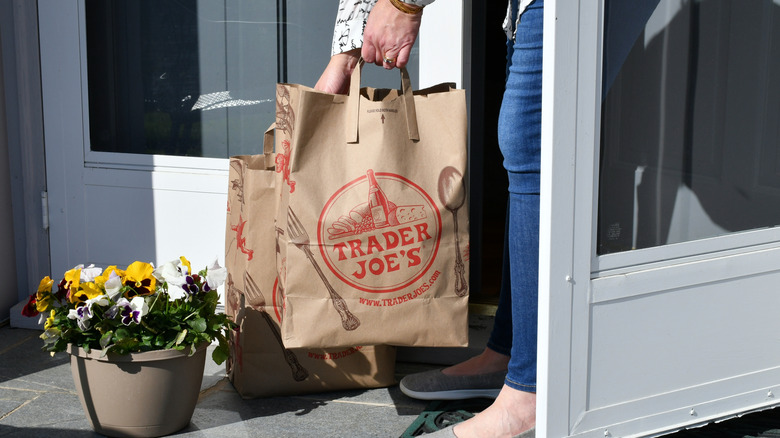 Person carrying Trader Joe's grocery bags
