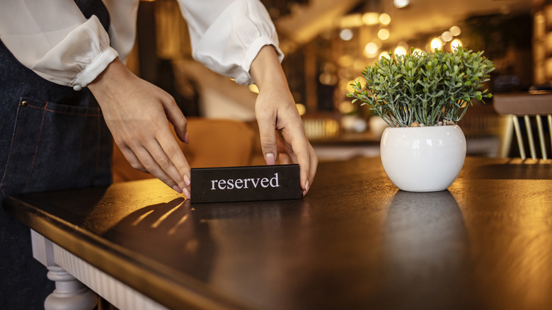 Restaurant worker placing reserved sign