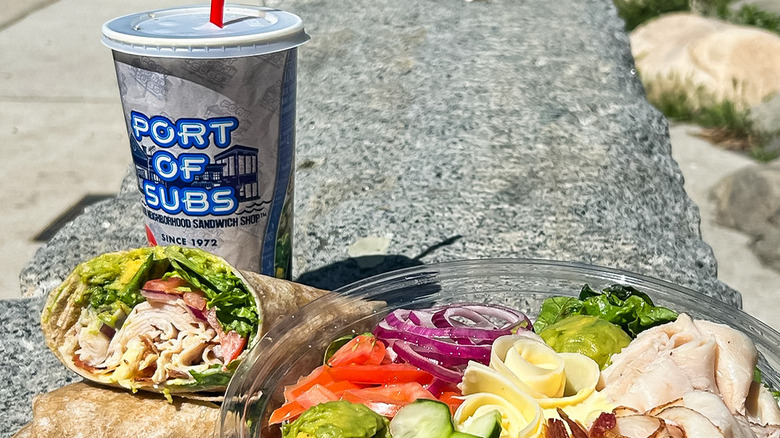 salad and wrap beside Port of Subs soda cup