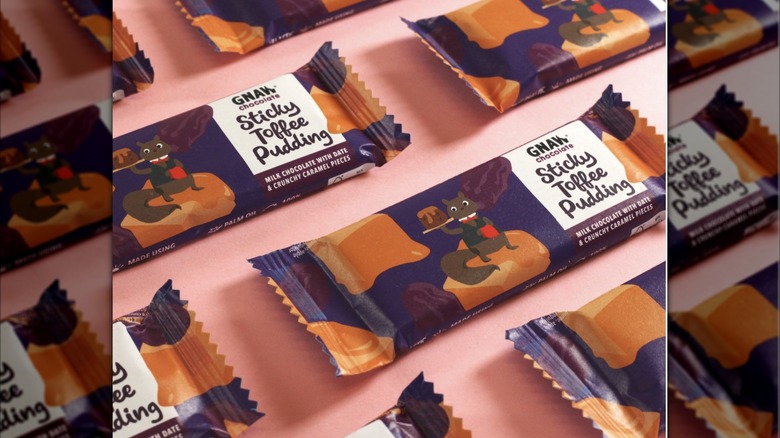 Gnaw Sticky Toffee Pudding bars in wrappers arranged on pink background