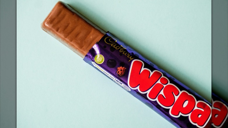 A Cadbury Wispa chocolate bar half out of its wrapper