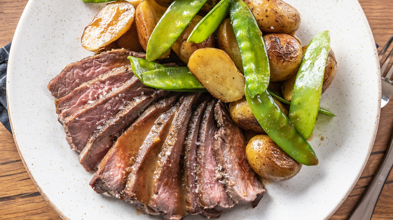sliced flank steak with potatoes