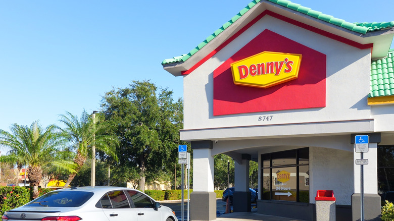 A car parked in front of a Denny's restaurant