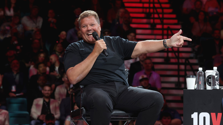 Jimmy John Liautaud speaks on a mic while seated onstage at a 10X event