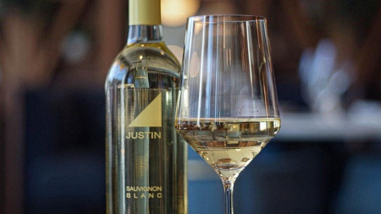Glass of white wine with the Justin bottle in the background