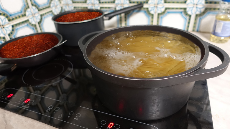 Spaghetti and sauce cooking on induction stove