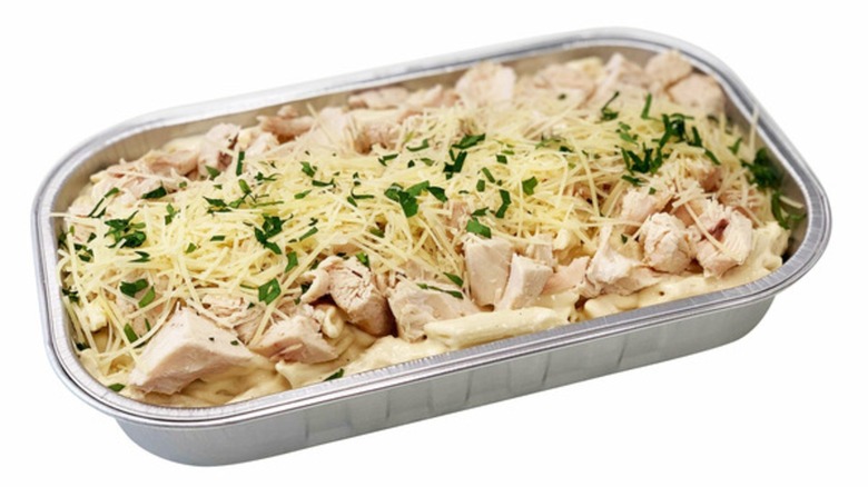 Open tray of the chicken Alfredo from Costco on white background