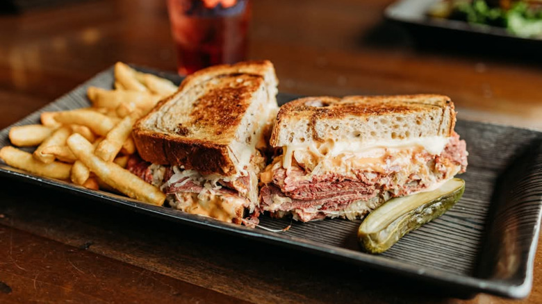 Pastrami sandwich with fries and pickle
