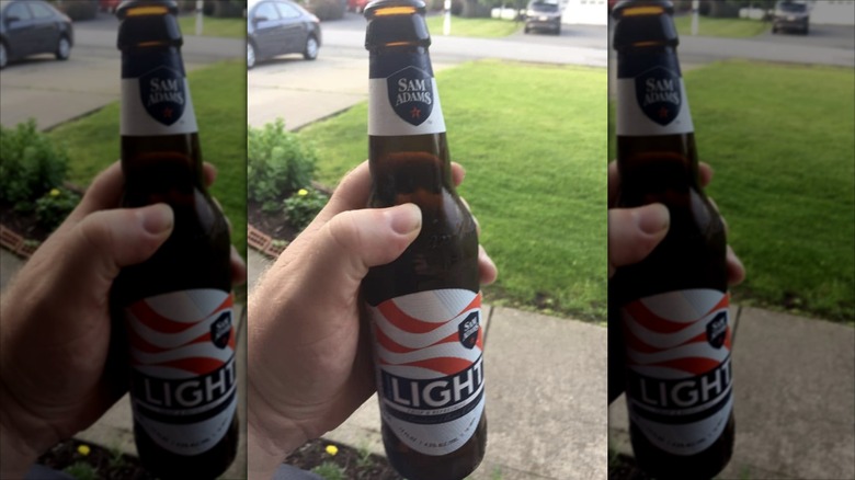 Hand holding bottle of Sam Adams Light