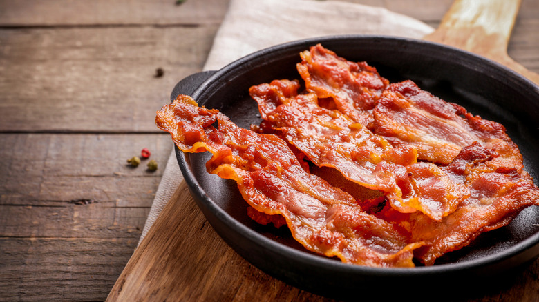 Cooked strips of bacon in a cast iron skillet