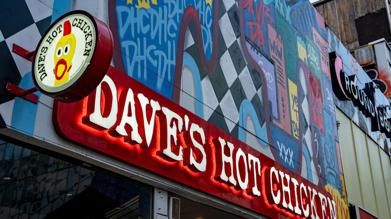 Dave's Hot Chicken signage against a graffiti-style mural