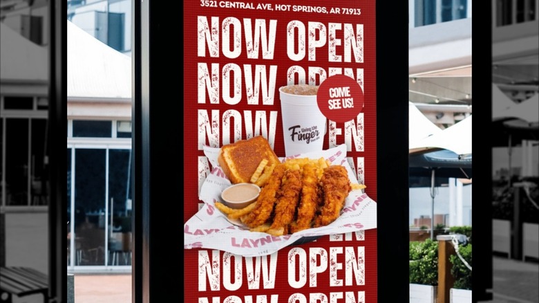 An outdoor poster advertisement for Layne's Chicken Fingers in Hot Springs, Arlington