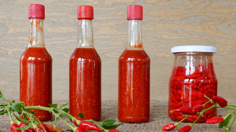 Bottles of hot sauce with chili peppers