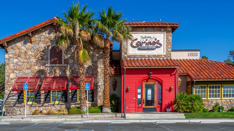 Exterior entrance of Johnny Carino's restaurant with palm trees and brick facade