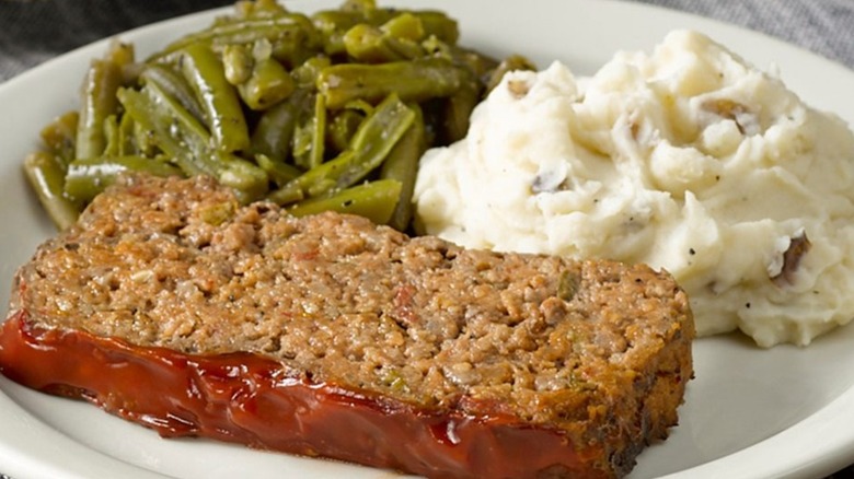 A slice of Cracker Barrel meatloaf with mashed potatoes and green beans