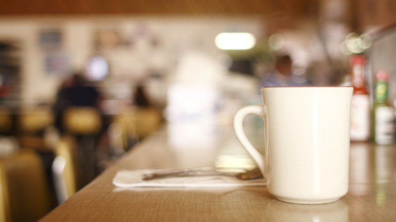 cup of coffee on counter at diner, background blurred