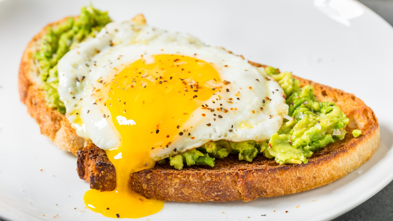 egg with runny yolk on slice of avocado toast