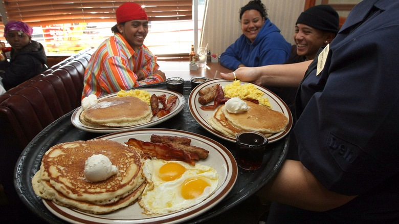 plates of breakfast food being served to customers in diner