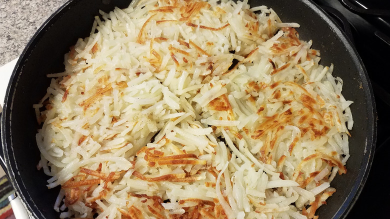 Hash browns cooking in a pan