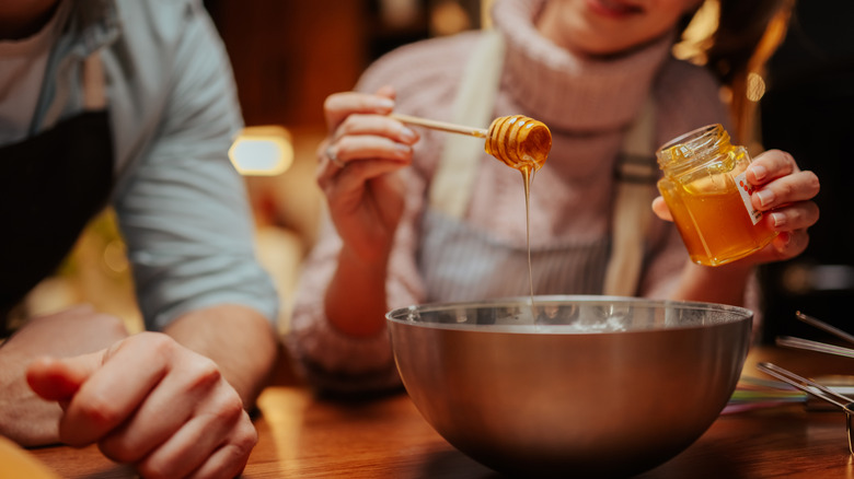 Woman drizzling honey into a bowl