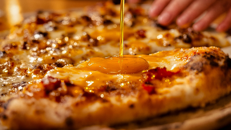 Honey being drizzled on pizza