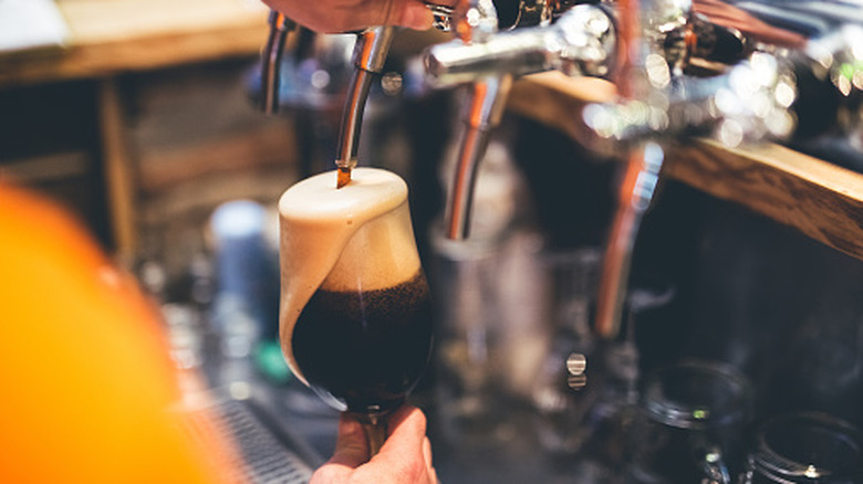 Bartender pouring a stout on tap