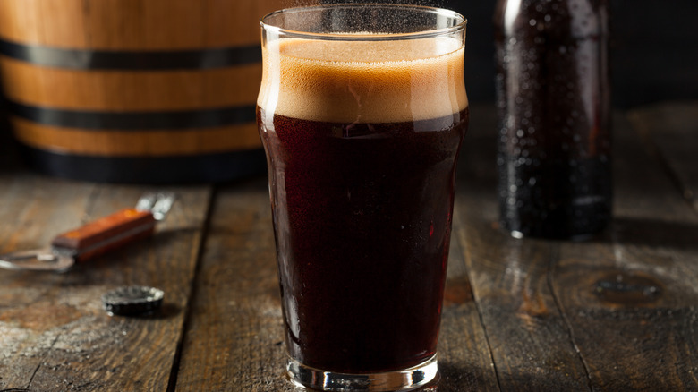 Pint glass of stout on wooden table