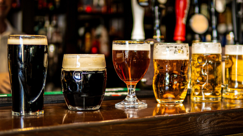 Various types of beer in glasses on bar
