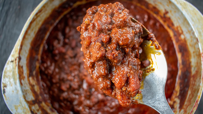 A spoonful of chili over a big pot