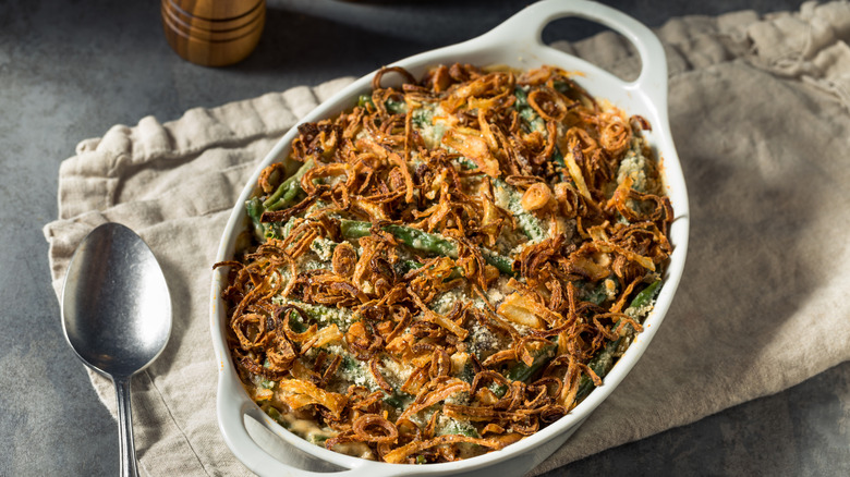 Green bean casserole in a white dish on a dish cloth