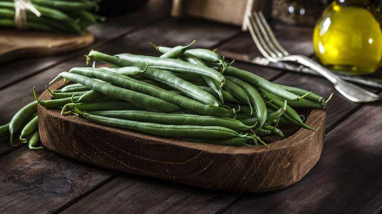 Fresh green beans on wooden platter