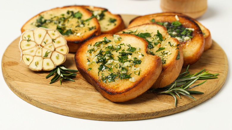 Slices of garlic bread on a wooden board