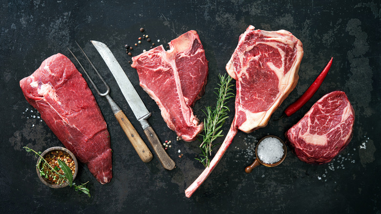 raw steaks black background