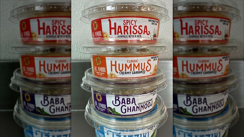 Stacks of hummus containers with spicy harissa and classic