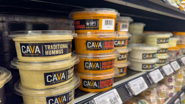 Stacks of CAVA hummus tubs on shelves at store