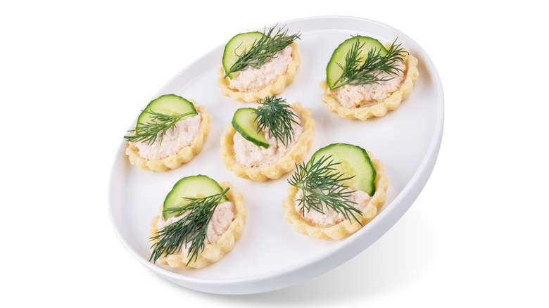 Salmon mousse in pastry tarts on a white plate