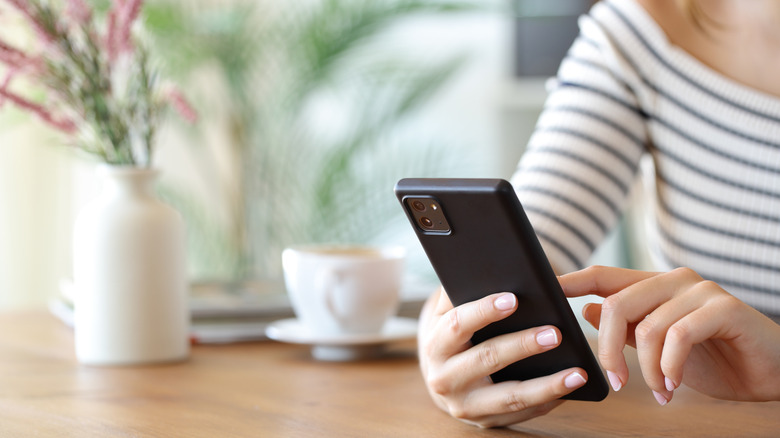A woman sitting down while using her smartphone