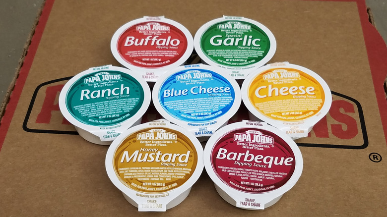 An array of Papa Johns dipping sauces on top of the pizza box