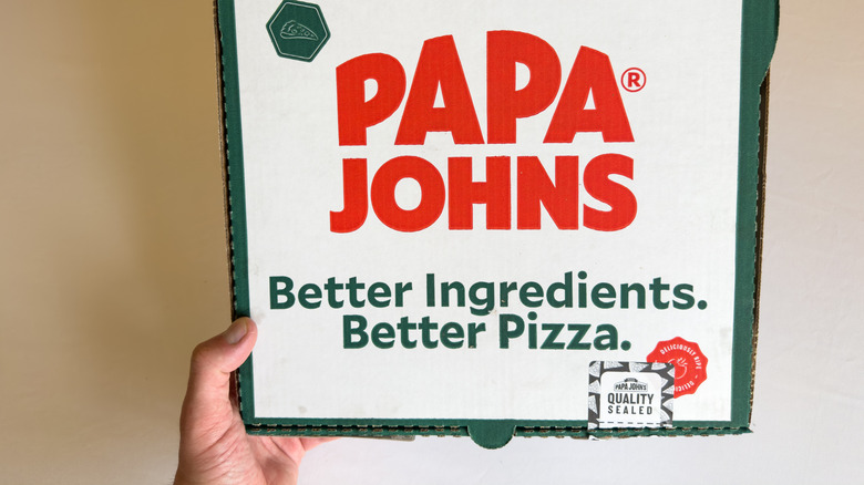 A person holding a Papa Johns pizza box