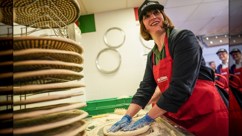 A Papa Johns employee working on pizza dough