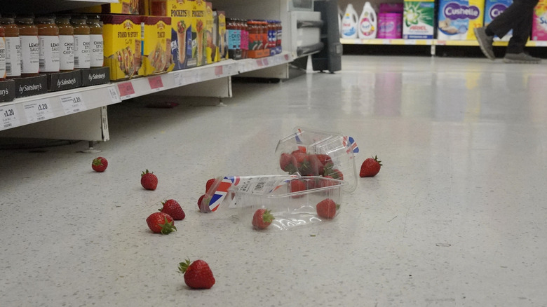 Spilled strawberries in supermarket aisle