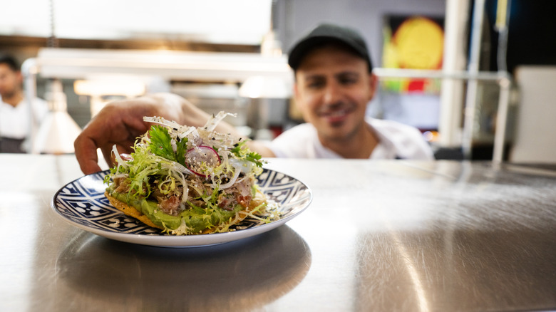 Chef placing food on the pass in a Mexican restaurant