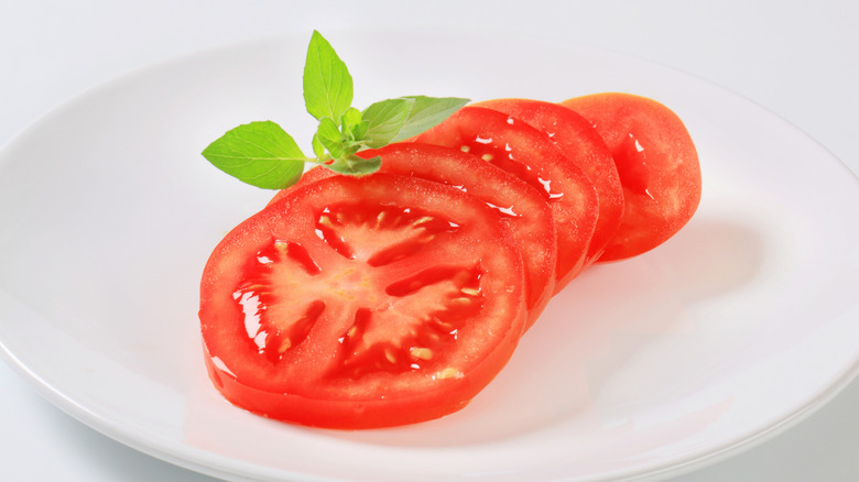 Fresh tomato slices on a white plate