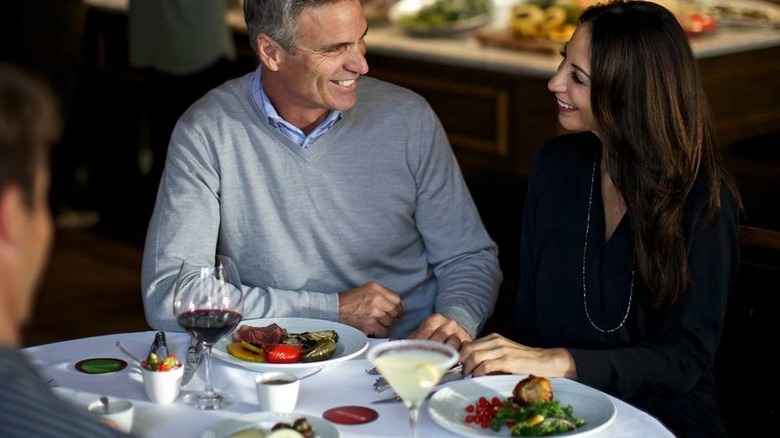 Man and woman at a table with the cards, one turned to red and one turned to green